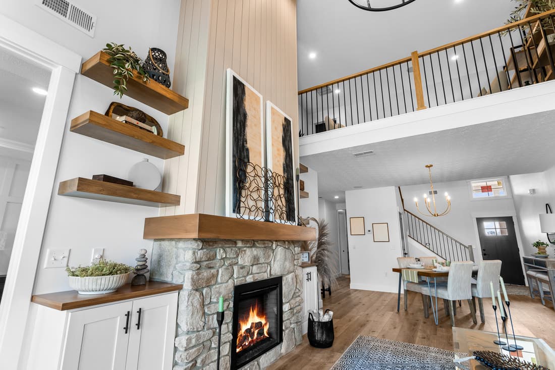 Great room with wood mantel, shelving, and stair railing