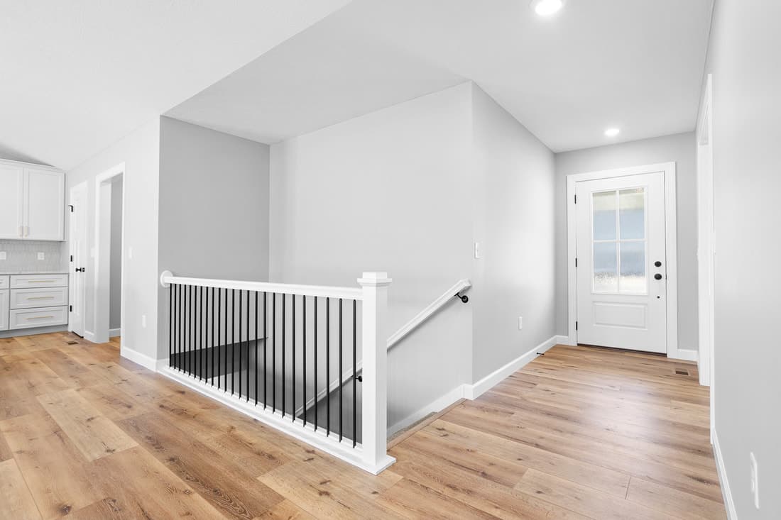 Bright stair landing with black iron balusters