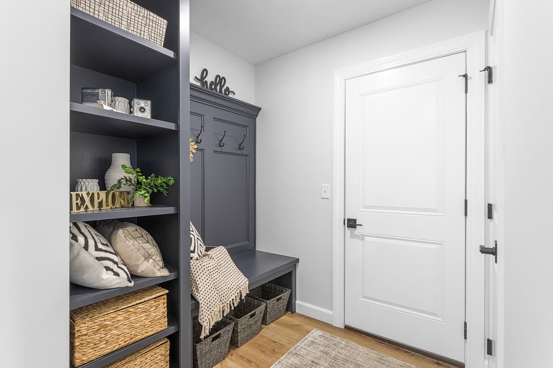Mudroom storage cabinet, bench, and white interior door