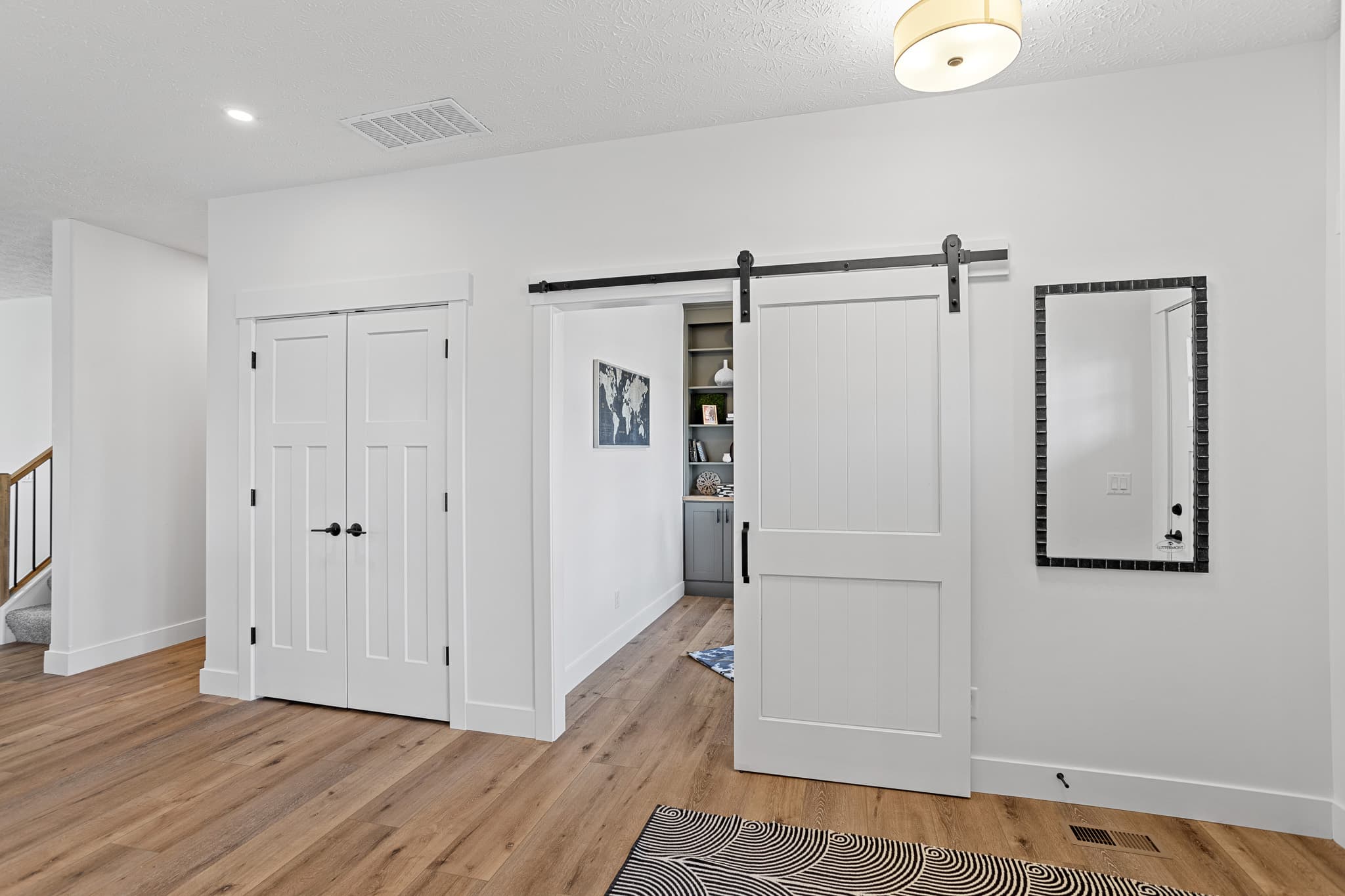 Paneled interior swing doors and a sliding barn door